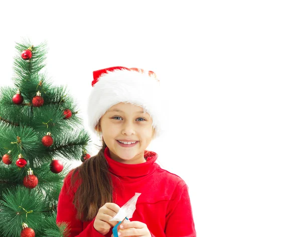 Beautiful little girl opens a Christmas gift tied with a blue ri — Stock Photo, Image