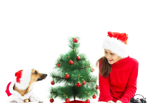 Liten flicka och röda hund klädd som jultomte — Stockfoto