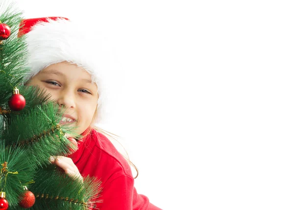 Meisje verkleed als Santa knuffelen een versierde kerstboom — Stockfoto