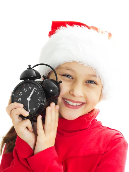 Portret van een glimlachende klein meisje in een kerstmuts houdt alar — Stockfoto