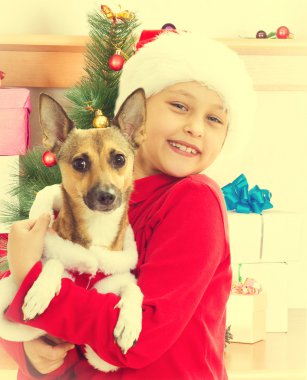 çocuk onun köpeğin yanına g tabloyla tutan Noel giysileri