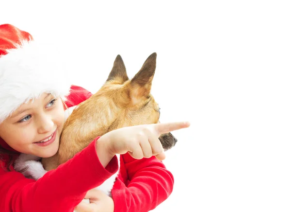 Liten flicka i Christmas kläder pekar fingret på en vit — Stockfoto