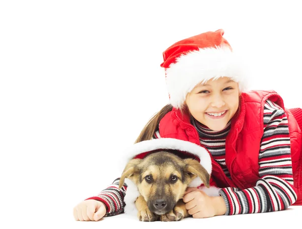 Mooi meisje in Kerstmis kleren knuffelen pup liggen o — Stockfoto