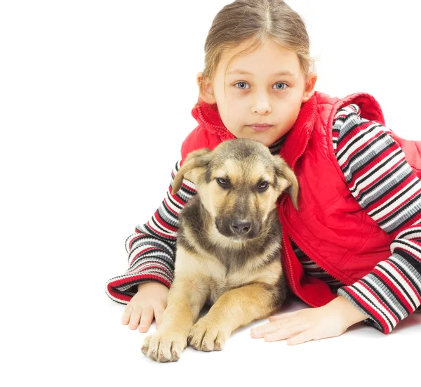 Portrait of a pretty little girl in a red vest and a puppy on a — Stock Photo, Image