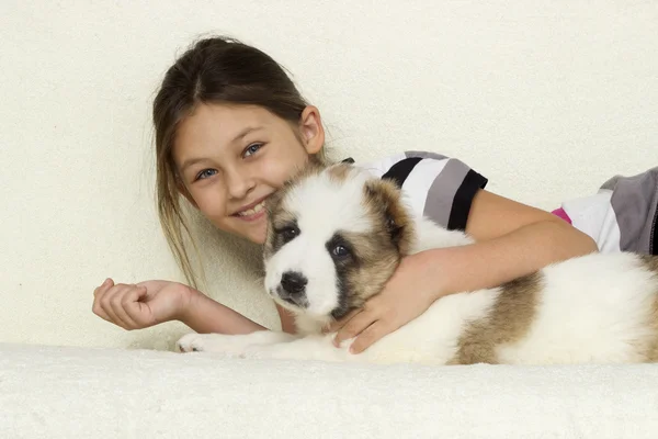 Kind umarmt sanft einen Welpen — Stockfoto