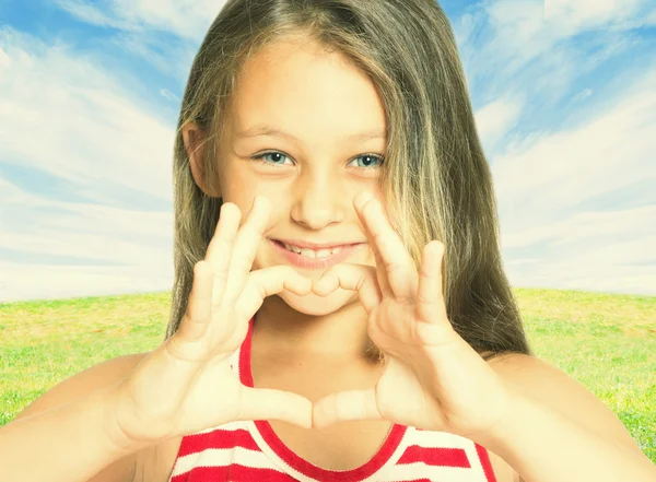 Kid shows hands gesture heart outdoors — Stock Photo, Image