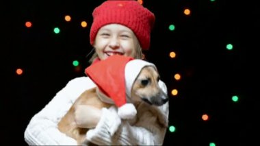 Noel Baba şapkası içinde köpek yavrusu ile kız