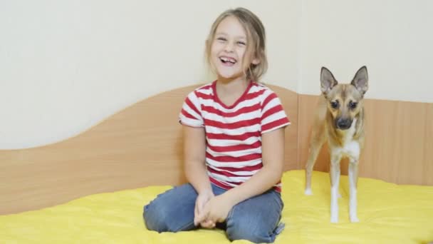 Kleines Mädchen mit Hund auf Couch — Stockvideo