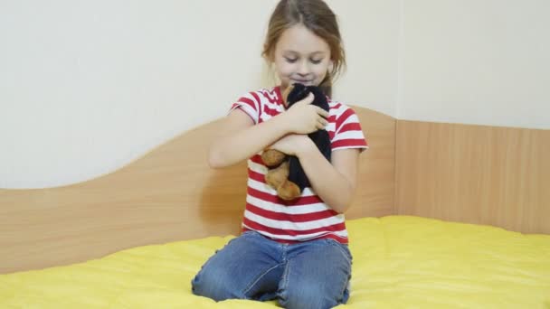 Menina com cão de brinquedo no sofá — Vídeo de Stock