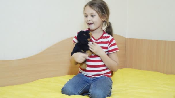 Menina com cão de brinquedo no sofá — Vídeo de Stock