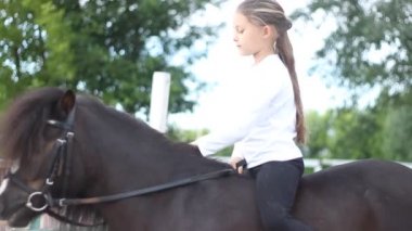 Bir midilli üzerinde oturan kız