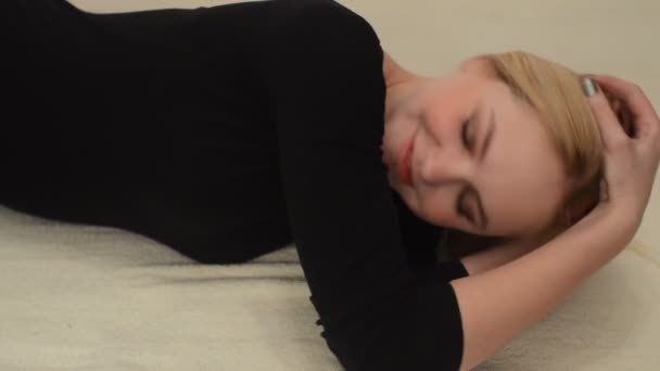 年轻的金发女人躺在床上 — 图库视频影像