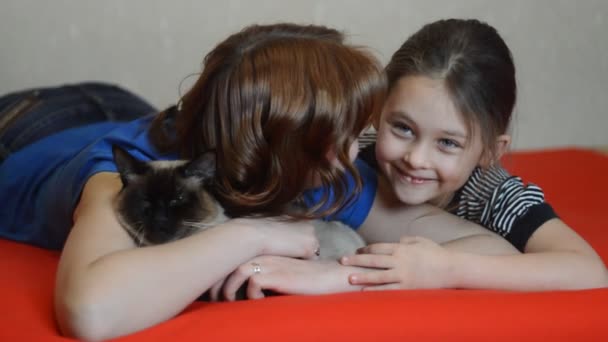 Сестры с домашней кошкой — стоковое видео