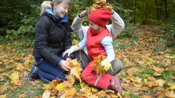 Mãe, pai e filha em folhas de outono — Vídeo de Stock