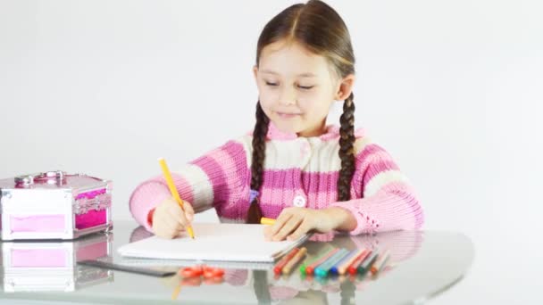 Klein meisje tekening aan tafel — Stockvideo