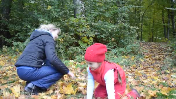 Мать и дочь с осенними листьями — стоковое видео
