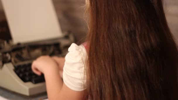 Little girl typing on a typewriter — Stock Video