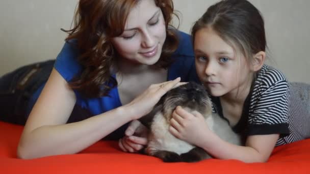 Сестры с домашней кошкой — стоковое видео