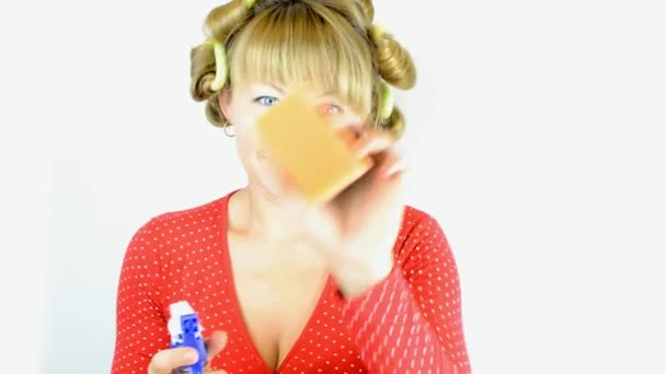 Huisvrouw in krulspelden met spray schonere — Stockvideo