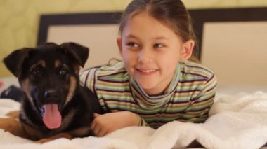 küçük kız yatakta köpek yavrusu