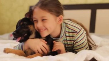 küçük kız yatakta köpek yavrusu