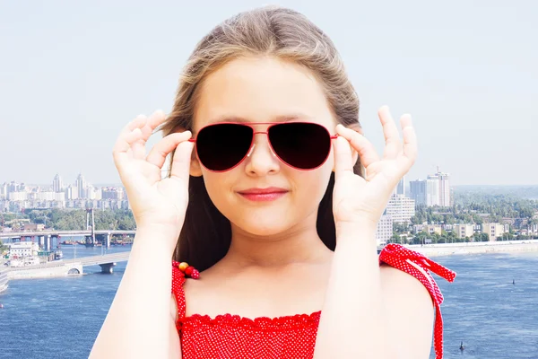 Mädchen mit Sonnenbrille vor dem Hintergrund der Stadt — Stockfoto