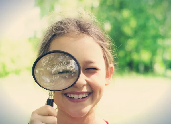 Funny child and magnifying glass — Stock Photo, Image
