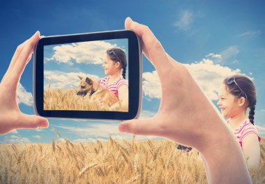 bir buğday alanında bir köpek ile Smartphone kız çekim