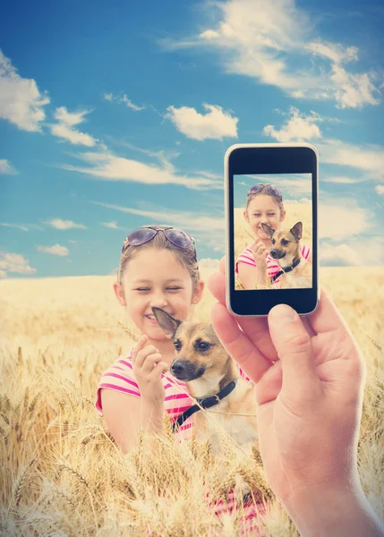 Fotograferen telefoon kind met een hond in tarwe — Stockfoto