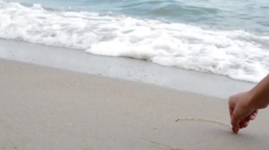 Deniz kumsalda, kalp işaret boya