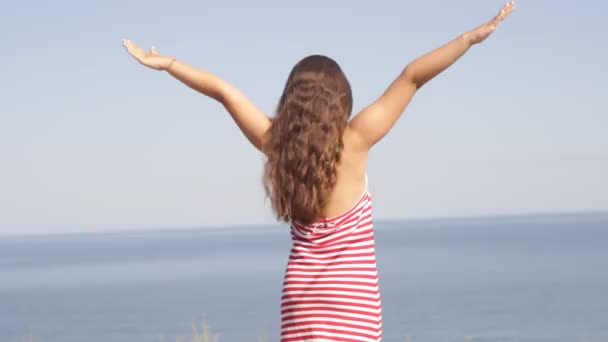 Fille debout sur une mer plage bras tendus — Video