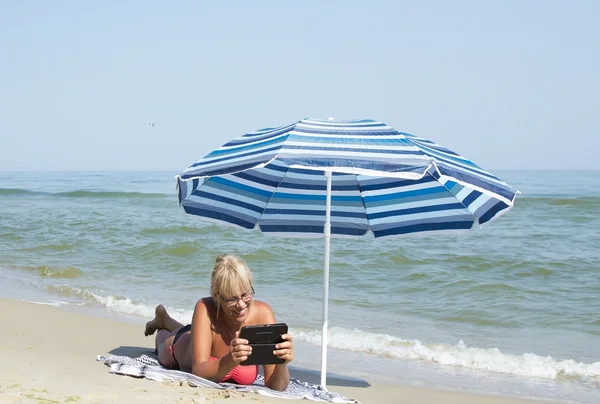 Woman and an electronic tablet to the sea Stock Image