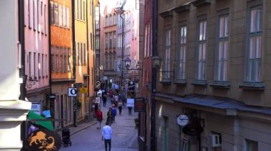 Stockholm 'ün merkezinde eski dar bir sokak. Eski kasaba. Mimarlık, eski evler, sokaklar ve mahalleler. İsveç. 4K 'da video, UHD