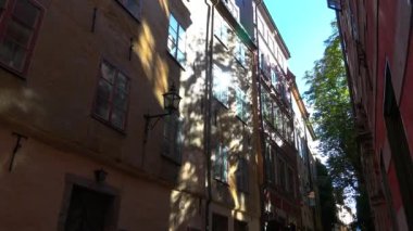 Stockholm 'ün merkezinde eski dar bir sokak. Eski kasaba. Mimarlık, eski evler, sokaklar ve mahalleler. İsveç. 4K 'da video, UHD