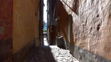 Stockholm 'ün merkezinde eski dar bir sokak. Eski kasaba. Mimarlık, eski evler, sokaklar ve mahalleler. İsveç. 4K 'da video, UHD