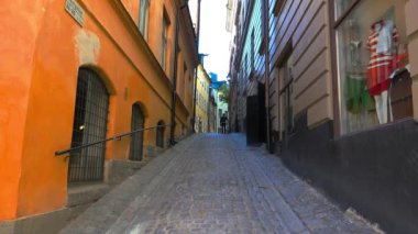 Stockholm 'ün merkezinde eski dar bir sokak. Eski kasaba. Mimarlık, eski evler, sokaklar ve mahalleler. İsveç. 4K 'da video, UHD