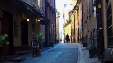 Stockholm 'ün merkezinde eski dar bir sokak. Eski kasaba. Mimarlık, eski evler, sokaklar ve mahalleler. İsveç. 4K 'da video, UHD