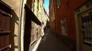 Stockholm 'ün merkezinde eski dar bir sokak. Eski kasaba. Mimarlık, eski evler, sokaklar ve mahalleler. İsveç. 4K 'da video, UHD