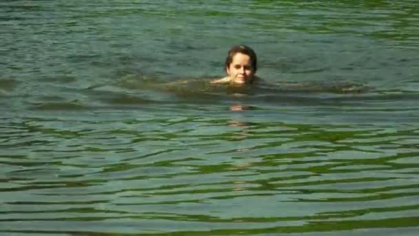 Красивая девушка купается в озере. 4K . — стоковое видео