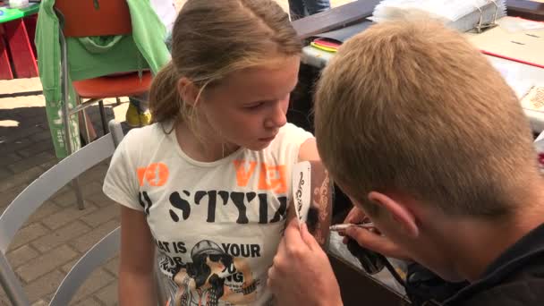 Adam kızın kolunda bir dövme uygulamak — Stok video