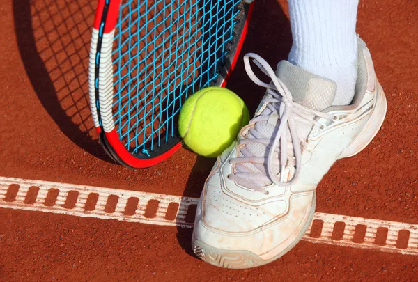 Gambe d'uomo vicino alla racchetta da tennis e palle — Foto Stock
