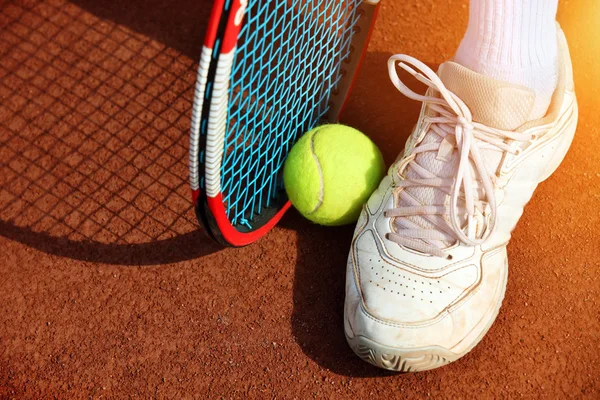 Ноги людини біля тенісного ракетки і м'ячі — стокове фото