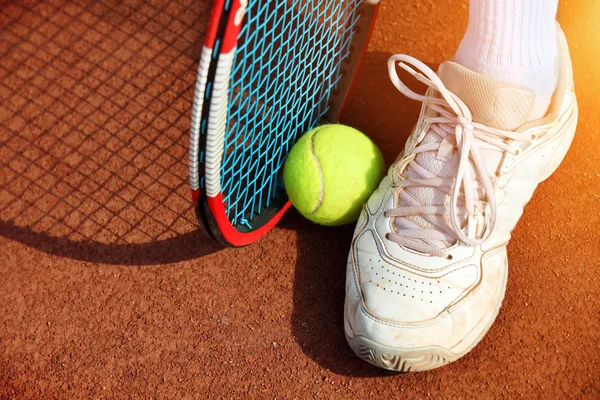 Las piernas del hombre cerca de la raqueta de tenis y pelotas —  Fotos de Stock