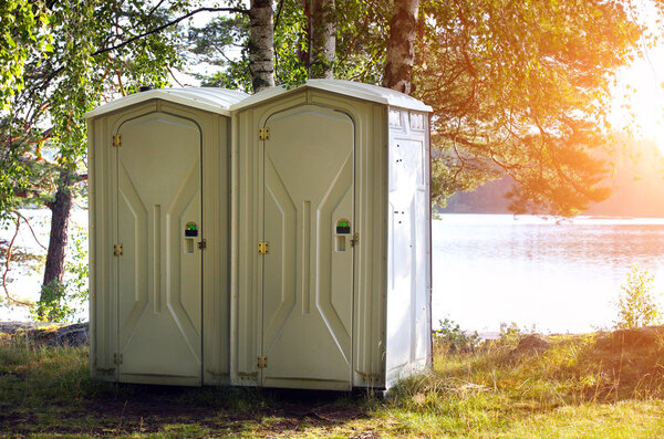 Two portable toilet or loo in blue plastic at a park