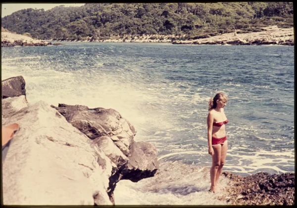 Özgün vintage renk slayttan 1960'larda, denize yakın duran genç kadın. — Stok fotoğraf