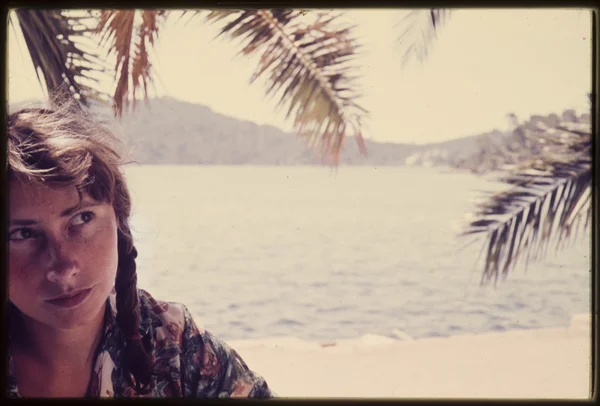 Original vintage  colour slide from 1960s, young woman sits by the sea. Stock Picture