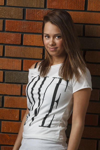 Mujer joven contra una pared de ladrillo —  Fotos de Stock