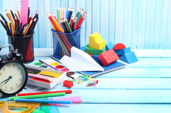 School supplies pencils crayons colorful assortment wooden background gentle blue tone