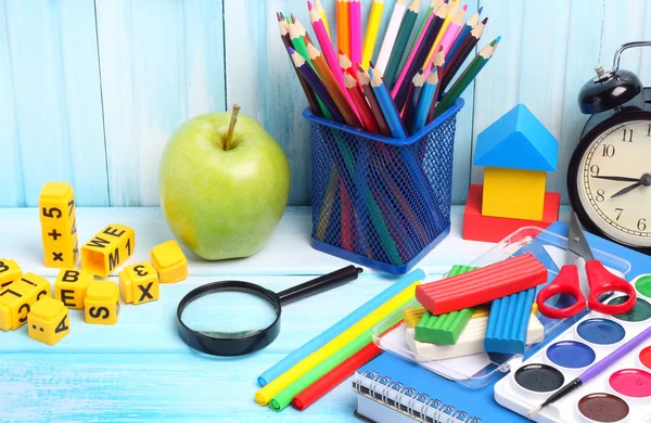 school supplies pencils crayons colorful assortment wooden background gentle blue tone
