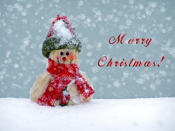 Feliz Navidad postal con un muñeco de nieve en la nieve — Foto de Stock